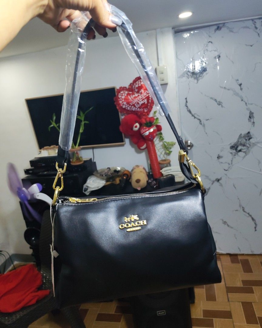 Coach Black Shoulder Bag with Gold Hardware (Category: Luxury Bags & Wallets) located in Caloocan City. Submitted by miyaka_lm (Listing ID 1469078651, Image 1). Description: - Brand new with tags still attached - Sleek black shoulder bag made from smooth material - Elegant gold-tone hardware and chain details - Straps still wrapped in protective plastic - Secure zippered compartments + external back zip pocket - Chic patterned fabric lining with 