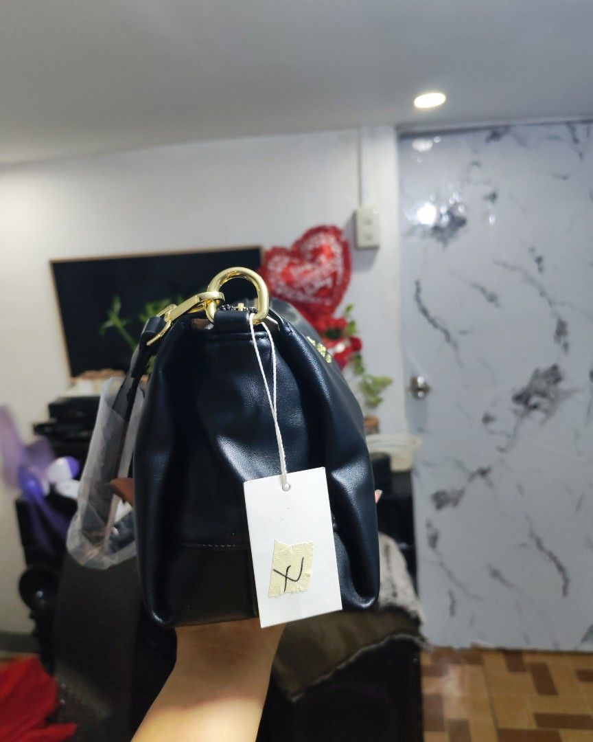 Coach Black Shoulder Bag with Gold Hardware (Category: Luxury Bags & Wallets) located in Caloocan City. Submitted by miyaka_lm (Listing ID 1469078651, Image 3). Description: - Brand new with tags still attached - Sleek black shoulder bag made from smooth material - Elegant gold-tone hardware and chain details - Straps still wrapped in protective plastic - Secure zippered compartments + external back zip pocket - Chic patterned fabric lining with 