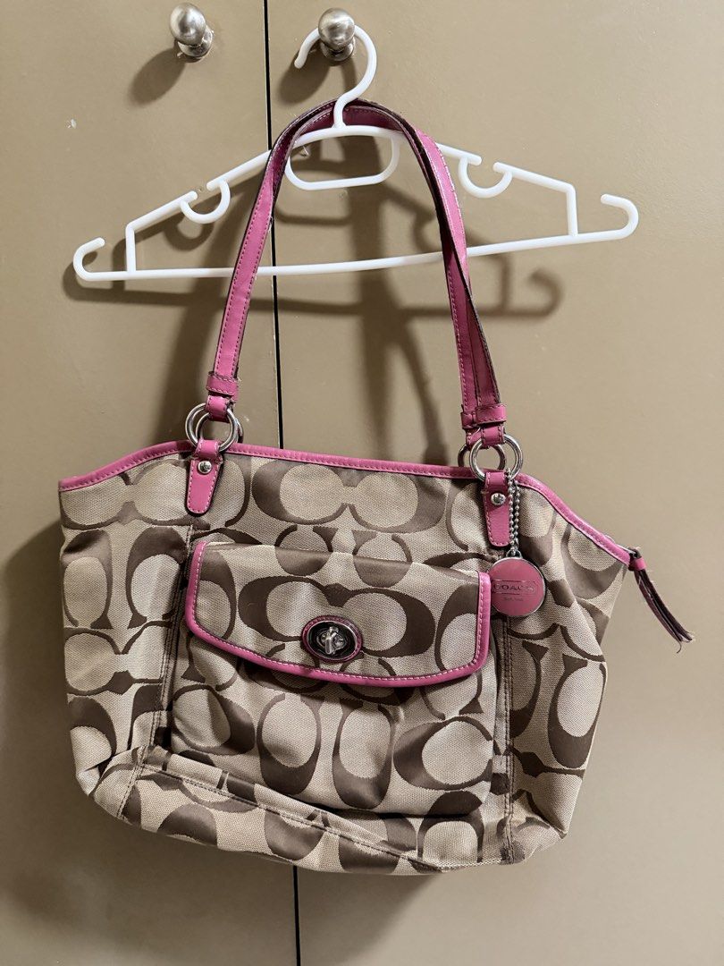 Coach Brown Pink Shoulder Bag (Category: Shoulder Bags) located in Quezon City. Submitted by labyrinthine.ph (Listing ID 1469063577, Image 1). Description: - Authentic Coach tote bag in khaki signature C jacquard fabric with pink leather trim - Features a front flap pocket with a secure turnlock closure and iconic pink hangtag - Convenient and secure top zip closure for daily essentials - Flaws to note: Visible cracking and wear along the handle 