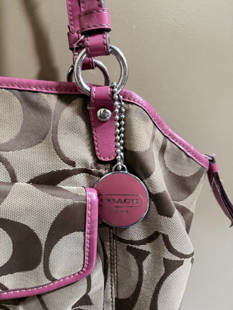 Coach Brown Pink Shoulder Bag (Category: Shoulder Bags) located in Quezon City. Submitted by labyrinthine.ph (Listing ID 1469063577, Image 2). Description: - Authentic Coach tote bag in khaki signature C jacquard fabric with pink leather trim - Features a front flap pocket with a secure turnlock closure and iconic pink hangtag - Convenient and secure top zip closure for daily essentials - Flaws to note: Visible cracking and wear along the handle 