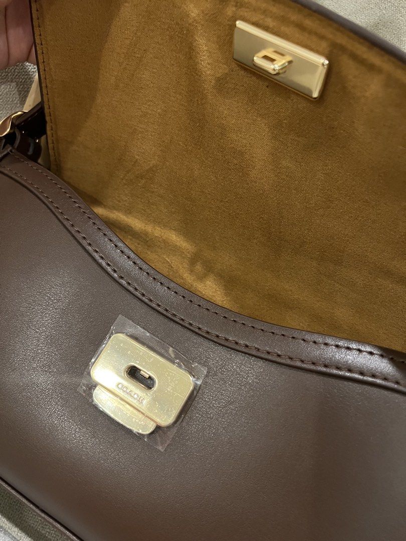 Coach Etta Flap (Category: Luxury Bags & Wallets) located in Manila. Submitted by orsaljoce25536 (Listing ID 1469005626, Image 3). Description: Coach shoulder bag in dark brown leather. Gold hardware, zip pocket inside, suede-like lining. Flap closure with turnlock. Includes an extra strap, still wrapped, plus a paper shopping bag. Clean interior and exterior, no scuffs..