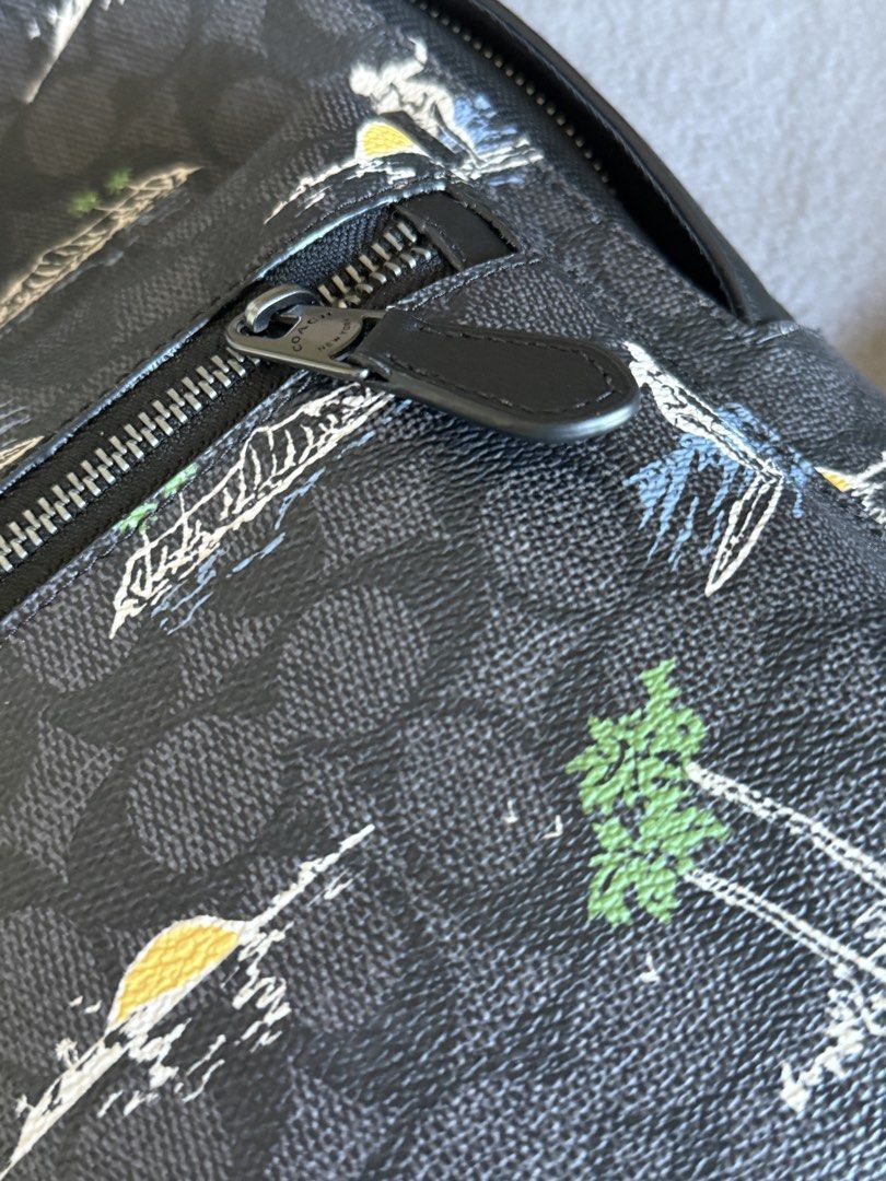 Coach Surfing Print Sling Backpack (Category: Backpacks) located in Pasig City. Submitted by laagn.ph (Listing ID 1468998638, Image 2). Description: - Brand: Coach - Color: Black with unique surfer and palm tree graphic - Condition: Brand new with original hang tag and store tag attached - Features: Adjustable strap, front zip pocket, and breathable mesh back panel - Perfect for: Daily commutes, travel, or casual everyday use - 100% Authentic.