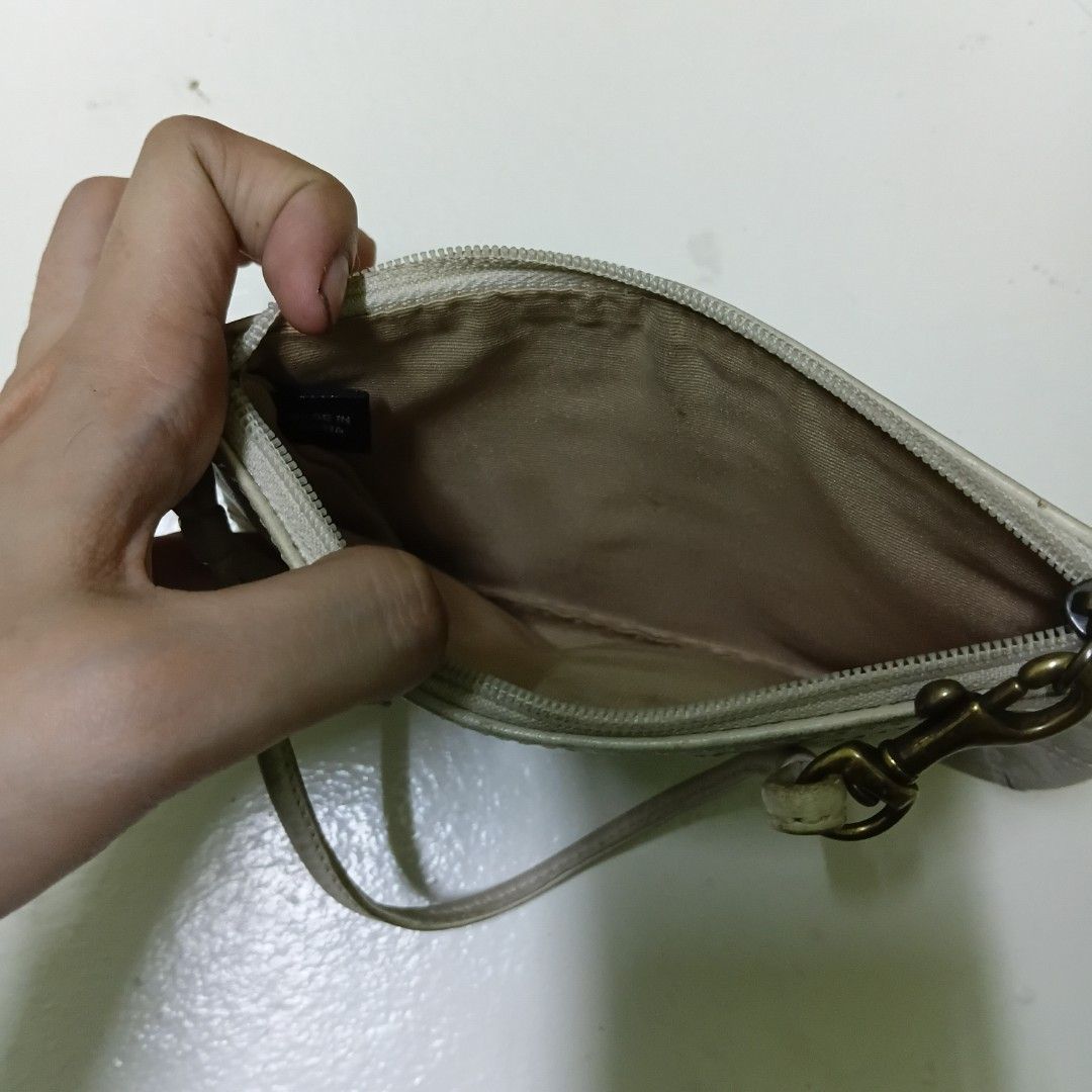 Coach White Leather Laced Wristlet (Category: Luxury Bags & Wallets) located in Manila. Submitted by daphnefinds1 (Listing ID 1469097342, Image 3). Description: - Brand: Coach - Material: White leather with brass-tone hardware - Design: Braided lace accent on the front, clean two-panel design on the back - Closure & Interior: Top zipper closure with fabric lining - Strap: Includes a detachable wrist strap - Condition: Pre-loved with visible signs