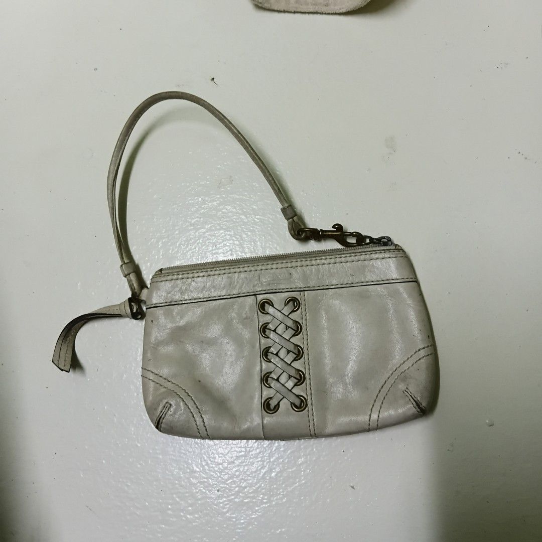 Coach White Leather Laced Wristlet (Category: Luxury Bags & Wallets) located in Manila. Submitted by daphnefinds1 (Listing ID 1469097342, Image 1). Description: - Brand: Coach - Material: White leather with brass-tone hardware - Design: Braided lace accent on the front, clean two-panel design on the back - Closure & Interior: Top zipper closure with fabric lining - Strap: Includes a detachable wrist strap - Condition: Pre-loved with visible signs