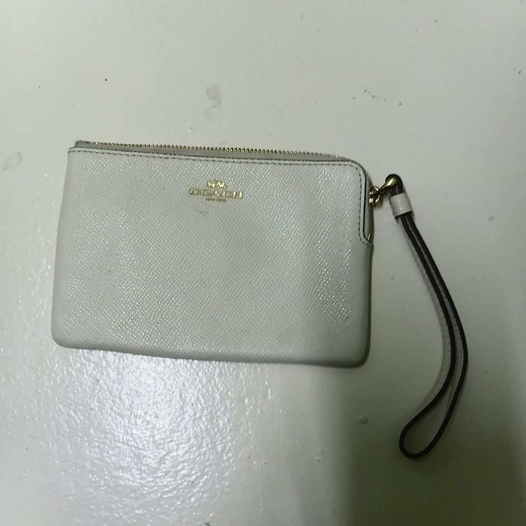 Coach White Leather Wristlet Wallet (Category: Wallets & Card holders) located in Manila. Submitted by daphnefinds1 (Listing ID 1469097395, Image 1). Description: White Coach wristlet wallet with gold hardware and zipper closure. Saffiano leather texture. Attached wrist strap on the side. Inside features dark lining with card slots. Made in Vietnam tag inside. Clean interior and exterior, ready to use for cards and cash..