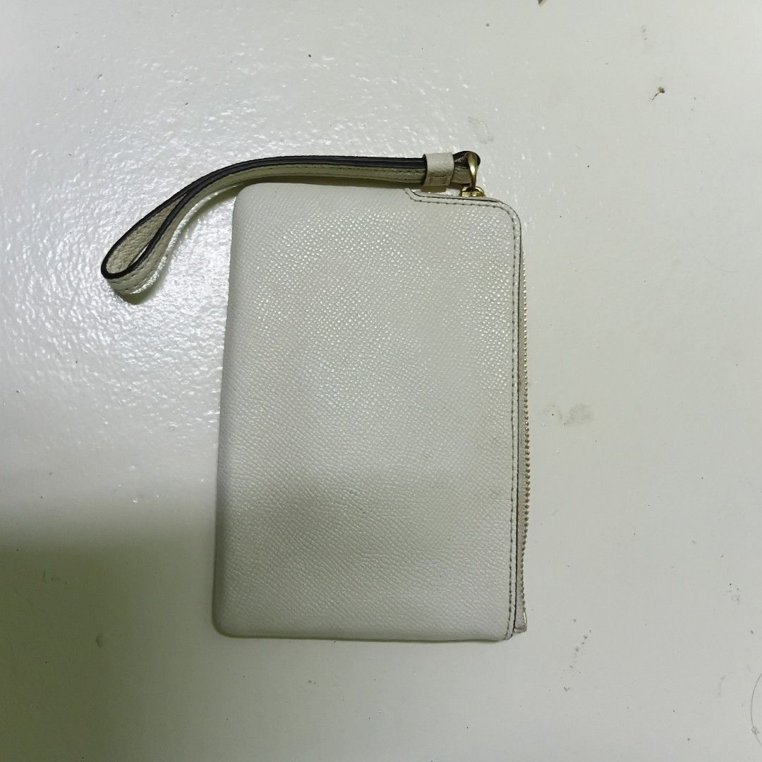Coach White Leather Wristlet Wallet (Category: Wallets & Card holders) located in Manila. Submitted by daphnefinds1 (Listing ID 1469097395, Image 2). Description: White Coach wristlet wallet with gold hardware and zipper closure. Saffiano leather texture. Attached wrist strap on the side. Inside features dark lining with card slots. Made in Vietnam tag inside. Clean interior and exterior, ready to use for cards and cash..