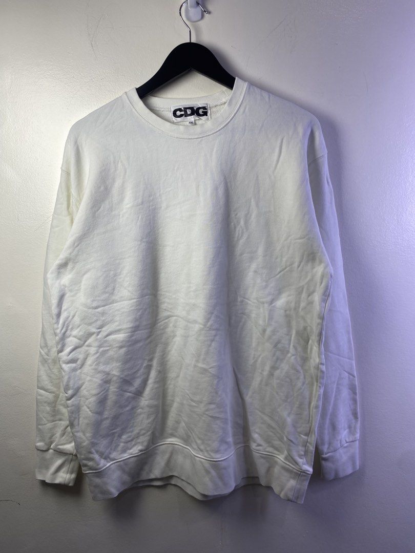 COMME des GARÇONS CDG White Sweatshirt XXL (Category: Coats, Jackets and Outerwear) located in Manila. Submitted by declutterpromax (Listing ID 1468997470, Image 1). Description: - Brand: Comme des Garçons (CDG) - Color: White with bold black back logo and star symbol - Size: XXL - Style: Classic crewneck, ribbed cuffs and hem - Condition: Clean look, easy to style with denim or joggers - Measurements: Provided in the photos.