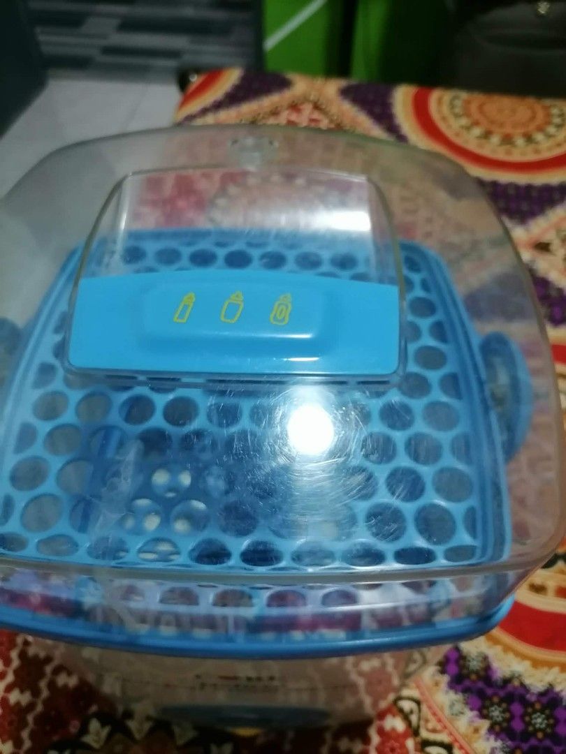 CORE Deluxe Electrical Steam Steriliser (Category: Breastfeeding & Bottle Feeding) located in Bulacan. Submitted by azilg23 (Listing ID 1469028373, Image 3). Description: - Brand/Model: CORE Deluxe Electrical Steam Steriliser - Color: White and Blue - Features: Clear lid, blue basket insert, and central rack - Controls: Simple power button and reset control on the front - Convenience: Handy carrying handles on the sides - Condition: Clean unit wi