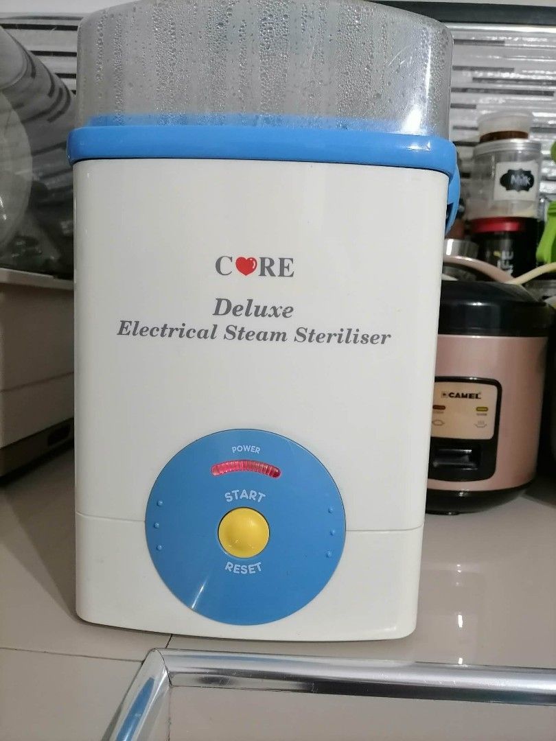 CORE Deluxe Electrical Steam Steriliser (Category: Breastfeeding & Bottle Feeding) located in Bulacan. Submitted by azilg23 (Listing ID 1469028373, Image 1). Description: - Brand/Model: CORE Deluxe Electrical Steam Steriliser - Color: White and Blue - Features: Clear lid, blue basket insert, and central rack - Controls: Simple power button and reset control on the front - Convenience: Handy carrying handles on the sides - Condition: Clean unit wi