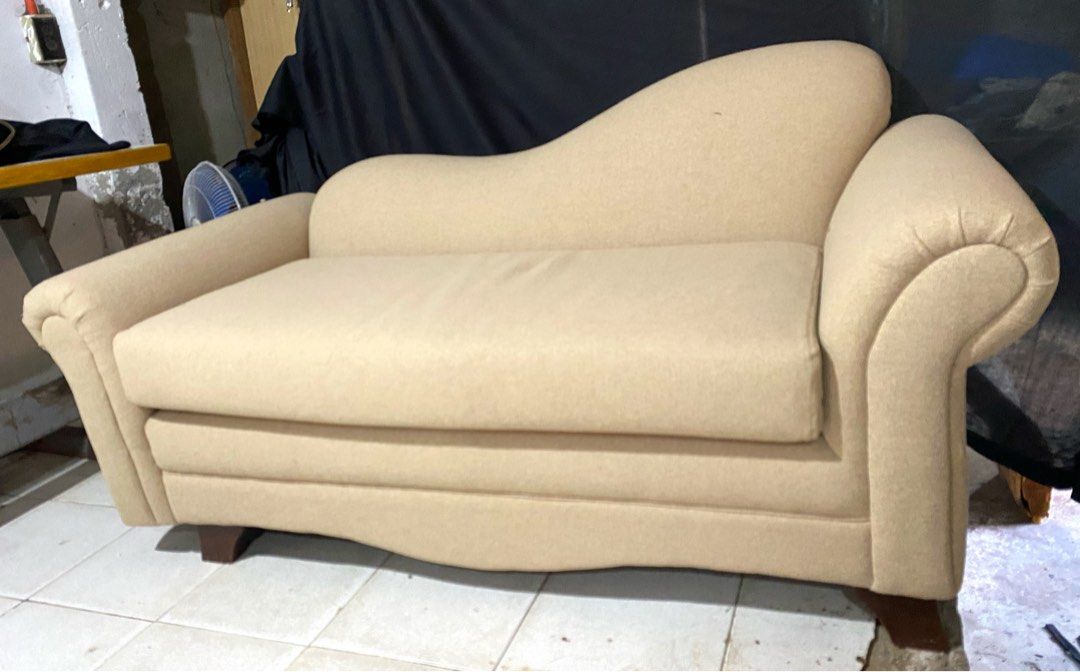 Cream Chaise Lounge Sofa with Rolled Arms (Category: Sofas) located in Quezon City. Submitted by agolicu (Listing ID 1469043181, Image 2). Description: - Cream-colored chaise lounge sofa with a stylish asymmetric backrest - Features cozy rolled armrests and deep cushioned seating - Includes a matching throw pillow for extra comfort - Supported by sturdy dark wooden tapered legs - Neutral fabric upholstery that easily blends with any living room d