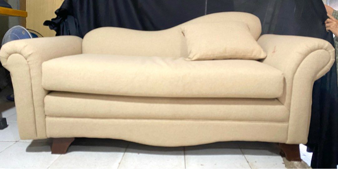 Cream Chaise Lounge Sofa with Rolled Arms (Category: Sofas) located in Quezon City. Submitted by agolicu (Listing ID 1469043181, Image 1). Description: - Cream-colored chaise lounge sofa with a stylish asymmetric backrest - Features cozy rolled armrests and deep cushioned seating - Includes a matching throw pillow for extra comfort - Supported by sturdy dark wooden tapered legs - Neutral fabric upholstery that easily blends with any living room d