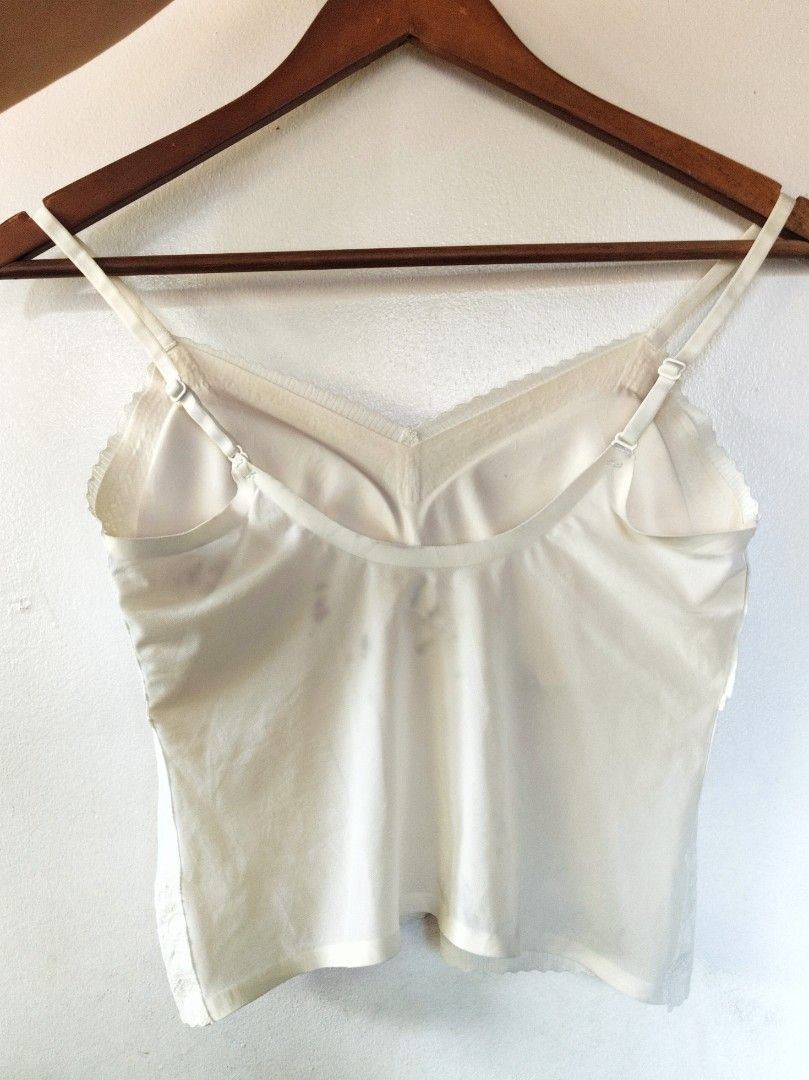 Cream Lace Padded Camisole Top (Category: Sleeveless) located in San Juan City. Submitted by rhennx (Listing ID 1469049929, Image 2). Description: - Color: Cream - Has stain at the back (see photos) - Style: V-neck camisole with floral lace trim on neckline and hem - Features: Built-in padding, adjustable straps, lightweight and stretchy fabric - Fit: Regular - Condition: Pre-loved with noticeable gray smudges on the back side (priced accordingly