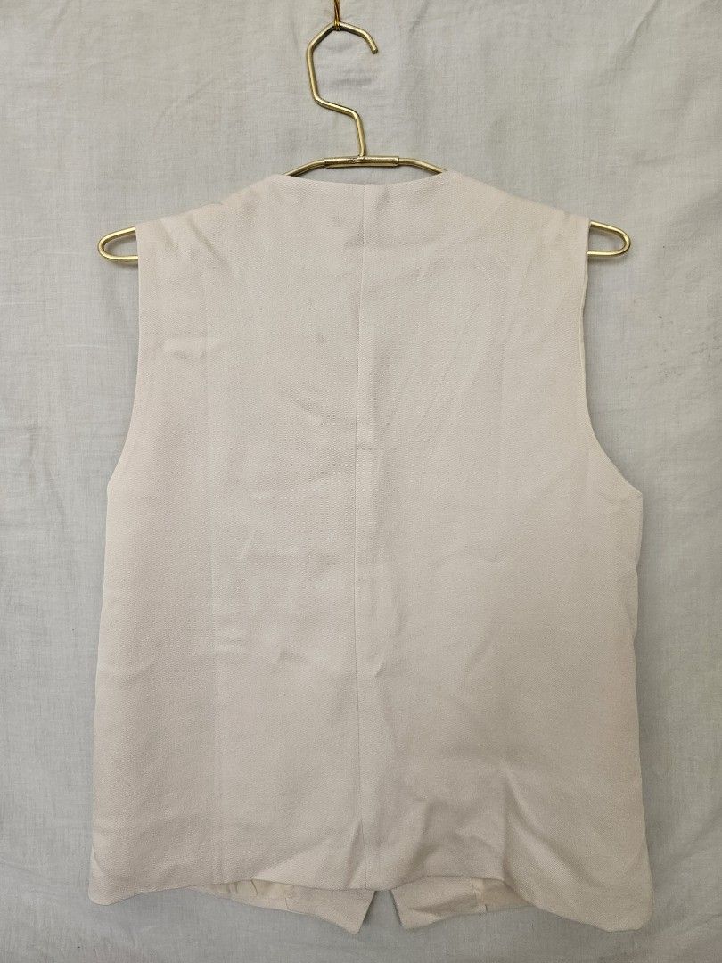 Cream Tailored Vest with Front Buttons and Pockets (Category: Sleeveless) located in Quezon City. Submitted by _pcloset (Listing ID 1469005356, Image 2). Description: - Color: Cream - Style: Button-up V-neck vest with tailored silhouette - Features: Front flap pockets, fully lined inside - Fit: Standard fit, sleeveless - Versatility: Neutral shade, perfect for layering or wearing solo.