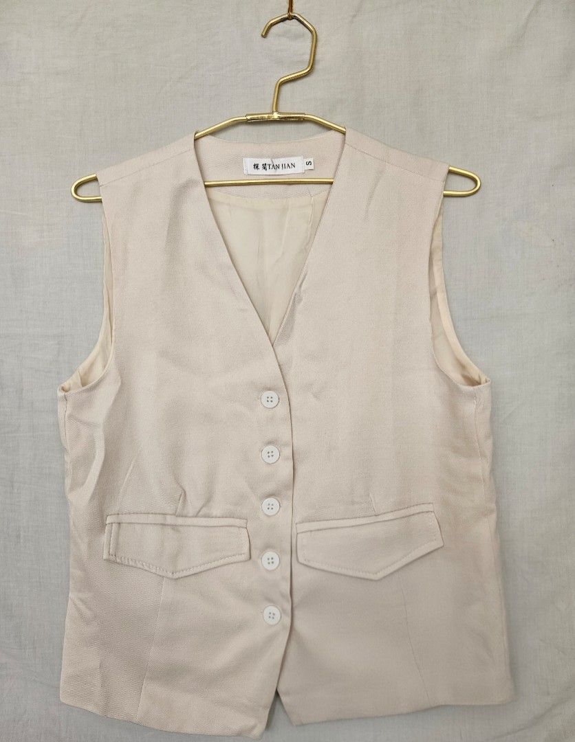 Cream Tailored Vest with Front Buttons and Pockets (Category: Sleeveless) located in Quezon City. Submitted by _pcloset (Listing ID 1469005356, Image 1). Description: - Color: Cream - Style: Button-up V-neck vest with tailored silhouette - Features: Front flap pockets, fully lined inside - Fit: Standard fit, sleeveless - Versatility: Neutral shade, perfect for layering or wearing solo.