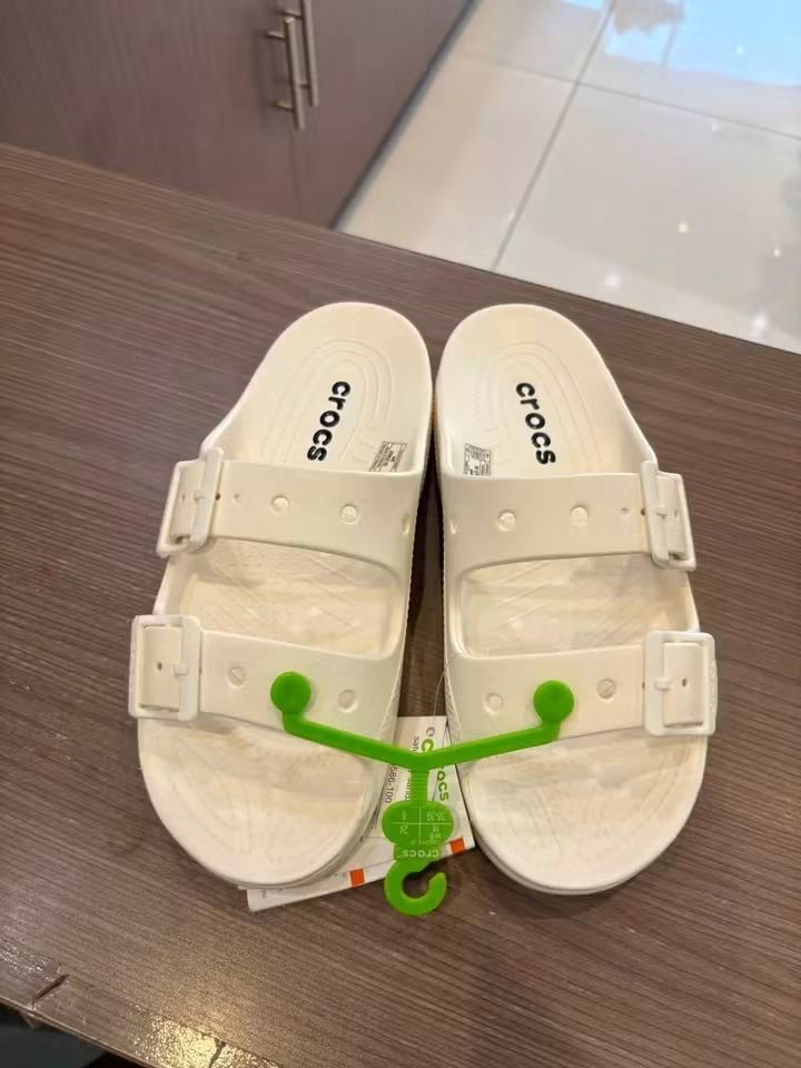 Crocs Classic Two Strap White Sandals Slippers (Category: Flats & Sandals) located in Cebu City. Submitted by madeskartegirl (Listing ID 1468983299, Image 1). Description: Size 5-9 available - Brand new with original store tags and green plastic hanger - Stylish white color with a clean, minimalist design - Double-strap slip-on style featuring two adjustable buckle closures - Textured footbed for enhanced grip and all-day comfort - Ideal for casu