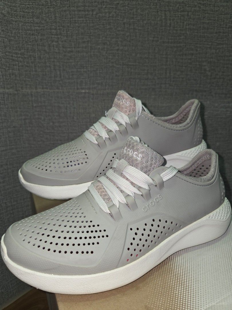 Crocs grey lace-up sneakers (Category: Sneakers) located in Manila. Submitted by isen45 (Listing ID 1469116522, Image 1). Description: - Brand: Crocs 8 womens size - Color: Grey with pink accents - Style: Lightweight slip-on sneakers with laces - Design: Perforated upper for breathability - Soles: Chunky white soles with reliable tread/grip - Interior: Comfortable pink mesh lining - Perfect for: Casual wear, errands, and walking.