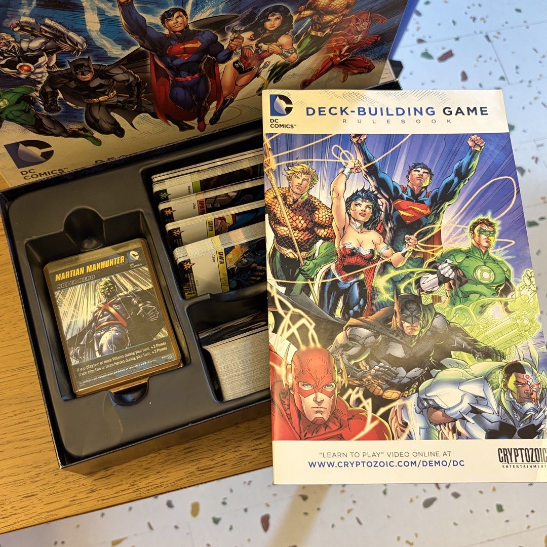 Cryptozoic Entertainment DC Comics Deck-Building Game (2012) (Category: Board Games & Puzzles) located in Cavite. Submitted by jace.themerchant (Listing ID 1469084825, Image 3). Description: Cryptozoic Entertainment DC Comics Deck-Building Game (2012) Package include: Original Box 1 Rulebook 7 Oversized Sealed Super Hero Cards (I used some proxy when I played this before so I didn’t need to open the packaging 214 Game Cards •36 Punch Starting Car