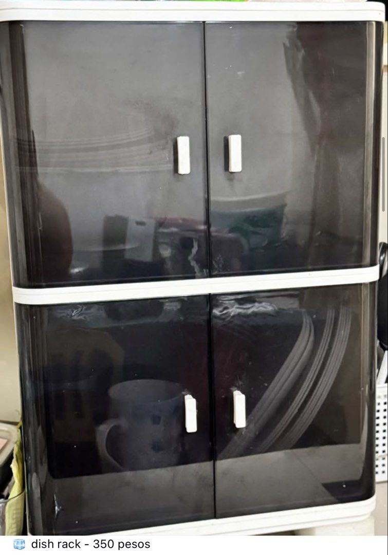 Dish rack with cabinet doors (Category: Food Organization & Storage) located in Valenzuela. Submitted by jjojacola (Listing ID 1468984040, Image 1). Description: Keep your kitchenware dust-free with this compact 2-tier white dish rack featuring dark tinted doors and convenient white handles. Perfect for organizing plates, mugs, and cups right on your countertop..