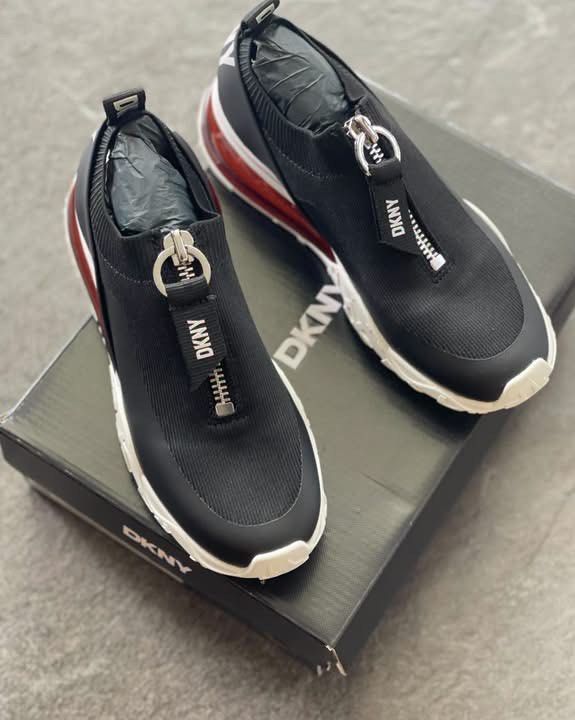 DKNY Black Zipper Platform Sneakers With Original Box (Category: Sneakers) located in Caloocan City. Submitted by Roowchelly (Listing ID 1469124644, Image 2). Description: - Brand: DKNY - Color: Black with chunky white and red sole - Style: Zip-up front with branded pull tab and slip-on stretchy knit upper - Details: Bold DKNY lettering on heel strap and pull loop - Inclusions: Original black shoebox included - Condition: Well-maintained and read