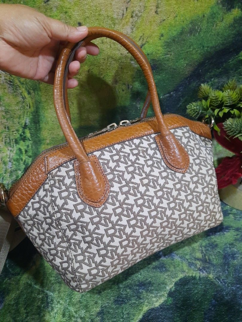 DKNY Monogram Crossbody Handbag Brown Beige (Category: Luxury Bags & Wallets) located in Baguio. Submitted by klayblakeb87803 (Listing ID 1469049647, Image 3). Description: - Brand: DKNY - Material: Signature monogram canvas with textured tan leather trim - Color: Brown and beige tones - Closure: Dual zipper with branded metal pulls - Handles & Strap: Dual top handles plus a detachable, adjustable crossbody strap - Protection: Bottom panel featur