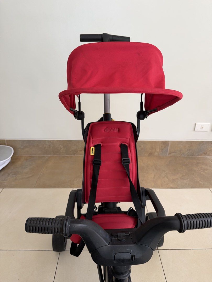 Doona Liki Trike S5 Foldable Tricycle (Category: Strollers) located in Makati City. Submitted by sellebrity88 (Listing ID 1468942777, Image 3). Description: - Item: Doona Liki Trike - Color: Red and black with yellow wheel accents - Type: Foldable push tricycle for toddlers - Features: Parent handle, sun canopy, and harness straps - Condition: Structurally sound frame and wheels; please note there are noticeable dark stains and mildew spots on to