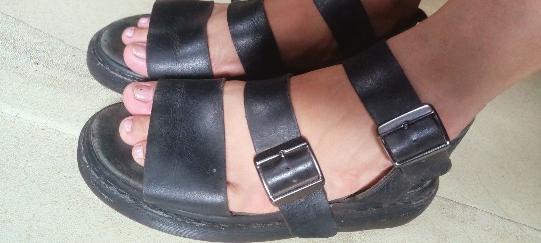 Dr. Martens Black Leather sandals (Category: Flats & Sandals) located in Tago. Submitted by fashionforless18 (Listing ID 1469008001, Image 2). Description: - Brand: Dr. Martens - Style: Black leather sandals with 3 adjustable buckle straps (top and ankle) - Features: Iconic chunky grooved sole with yellow welt stitching and dark gunmetal hardware - Condition: Pre-loved with natural leather creasing and minor scuffs on the soles - Perfect for: Eve