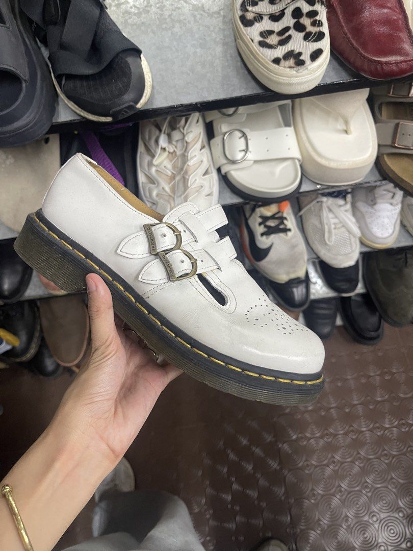 Dr. Martens White Multi-Strap Mary Jane Shoes (Category: Flats & Sandals) located in Balanga. Submitted by crowjo (Listing ID 1469060075, Image 2). Description: - Brand: Dr. Martens - Style: Mary Jane with double buckle straps & antique brass hardware - Color: Classic White - Details: Brogue toe perforation & iconic yellow sole stitching - Condition: Visible scuffing on the front toe area, interior logo stamp intact - Perfect for: Edgy, school-gi