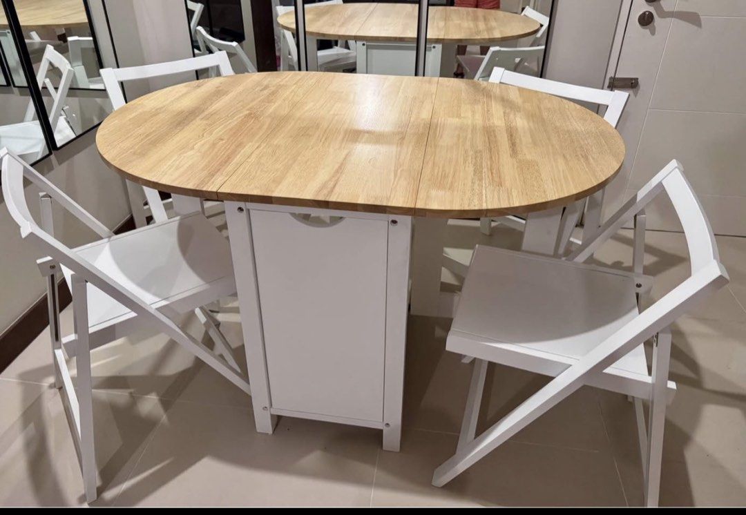 Adjustable dining table with 4 folding chairs white and light wood (Category: Tables & Sets) located in Manila. Submitted by akocwelen (Listing ID 1468982204, Image 1). Description: - Space-saving round wooden dining table with drop-down leaves - Converts into a compact rectangular console when folded - Includes 4 white folding chairs that store neatly inside the base unit - Natural wood tabletop finish with clean white frames - Ideal for apartme