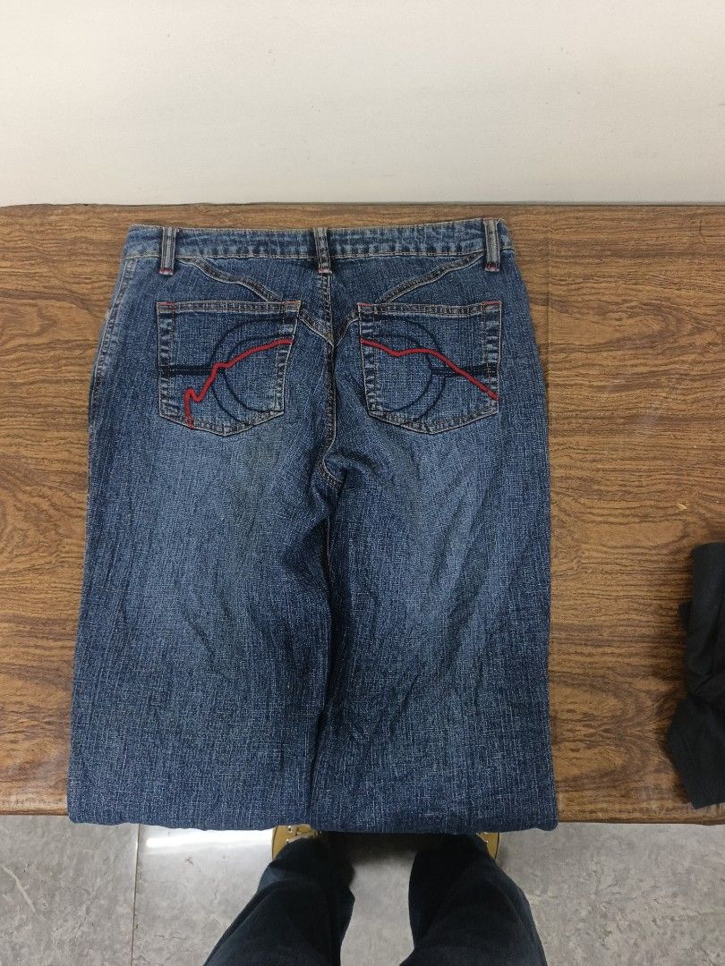 Ecko Red embroidered denim jeans (Category: Jeans) located in Manila. Submitted by criss_11 (Listing ID 1469102748, Image 2). Description: - Vintage Ecko Red denim jeans in a classic blue wash - Large embroidered lettering and iconic rhino logo down the right leg - Unique red contrast stitching on back pockets over dark wash details - Mid-rise fit with standard button and zipper fly - Perfect throwback piece for an authentic Y2K streetwear look.