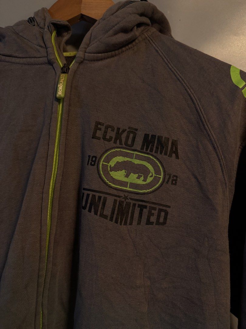 Ecko Unltd MMA Gray Full Zip Hoodie (Category: Coats, Jackets and Outerwear) located in Alaminos. Submitted by outfitcheck.ph (Listing ID 1469101285, Image 2). Description: - Brand: Ecko Unltd MMA Division - Color: Gray with neon green accents on zipper, lining, and shoulders - Size: Medium (inner tag verified) - Design: Large iconic rhino logo graphic print on chest and back - Features: Two front zip pockets, ribbed cuffs, and hem - Condition: E