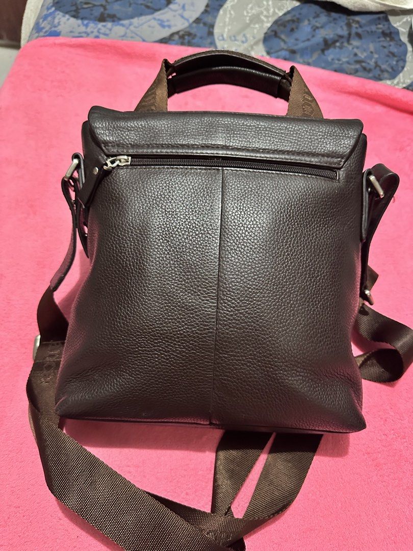 Elegance brown leather messenger bag (Category: Sling Bags) located in Quezon City. Submitted by pongoy (Listing ID 1469008089, Image 3). Description: - Brand: Elegance - Material: Brown leather in a deep brown colorway - Design: Textured geometric front panel with a vertical striped accent - Closure: Flap closure with a secure magnetic snap - Strap: Adjustable brown fabric shoulder strap featuring woven branding - Storage: Convenient back zipper