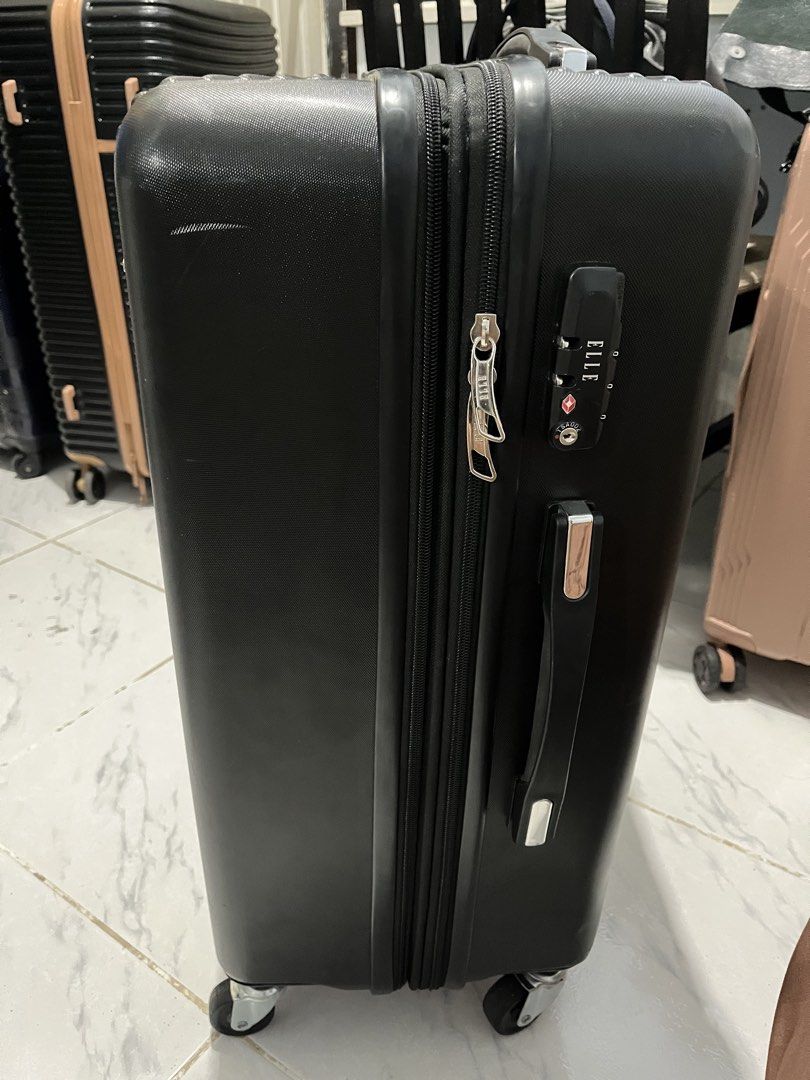 Elle black luggage (Category: Luggage) located in Marikina City. Submitted by patpatndls (Listing ID 1469135869, Image 3). Description: - Brand: Elle - Color: Black - Size: Medium (23-24 inches) - Design: Modern ribbed hardshell exterior with silver hardware and Elle logo badge - Security: Built-in combination lock - Mobility: Smooth-rolling multi-directional wheels with a sturdy retractable handle - Interior: Fully lined with multiple zippered m
