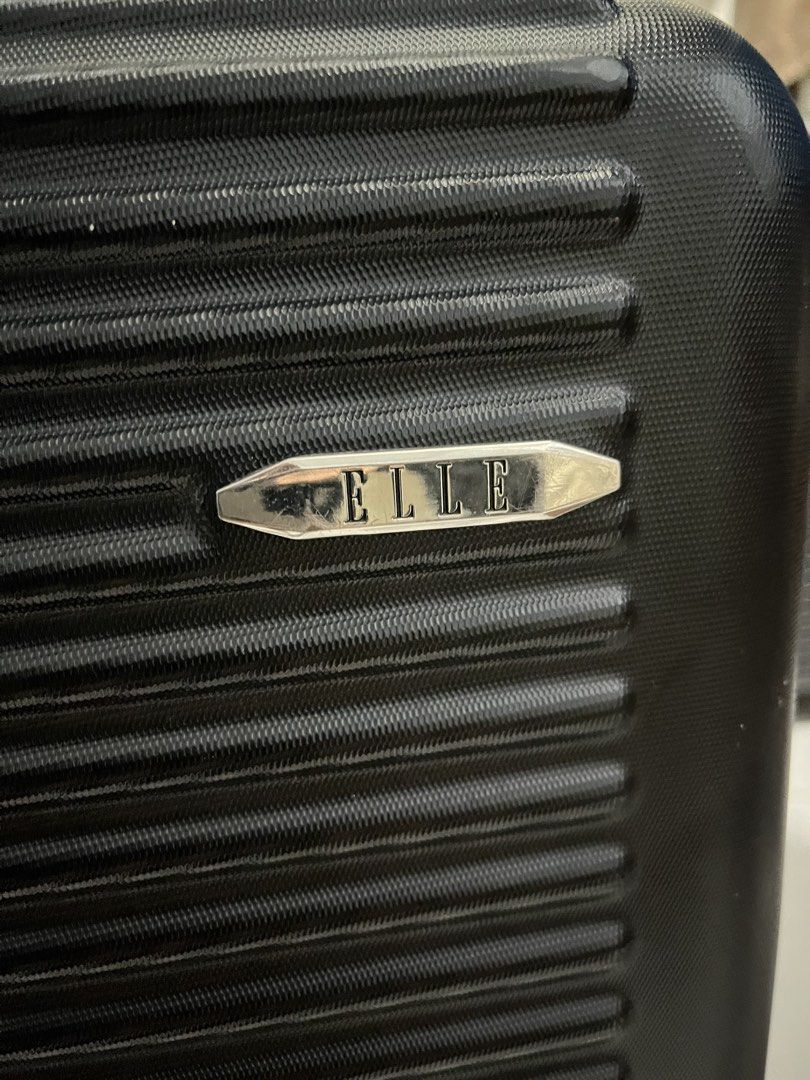 Elle black luggage (Category: Luggage) located in Marikina City. Submitted by patpatndls (Listing ID 1469135869, Image 2). Description: - Brand: Elle - Color: Black - Size: Medium (23-24 inches) - Design: Modern ribbed hardshell exterior with silver hardware and Elle logo badge - Security: Built-in combination lock - Mobility: Smooth-rolling multi-directional wheels with a sturdy retractable handle - Interior: Fully lined with multiple zippered m