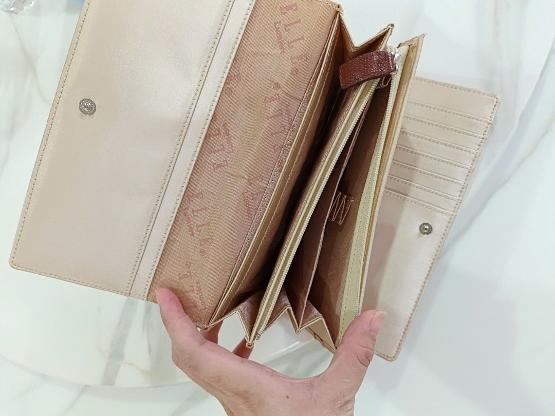 Elle Lumiere Beige Long Wallet (Category: Wallets & Card holders) located in Angeles City. Submitted by wanday_dreamer (Listing ID 1468983097, Image 3). Description: Elle Lumiere long wallet in beige. Snap button closure on the front flap. Inside has multiple card slots, bill compartments, and a zippered pocket. Branded fabric lining inside. Brown accent patch with the Elle logo on the outside. Clean interior and exterior, plenty of space for car