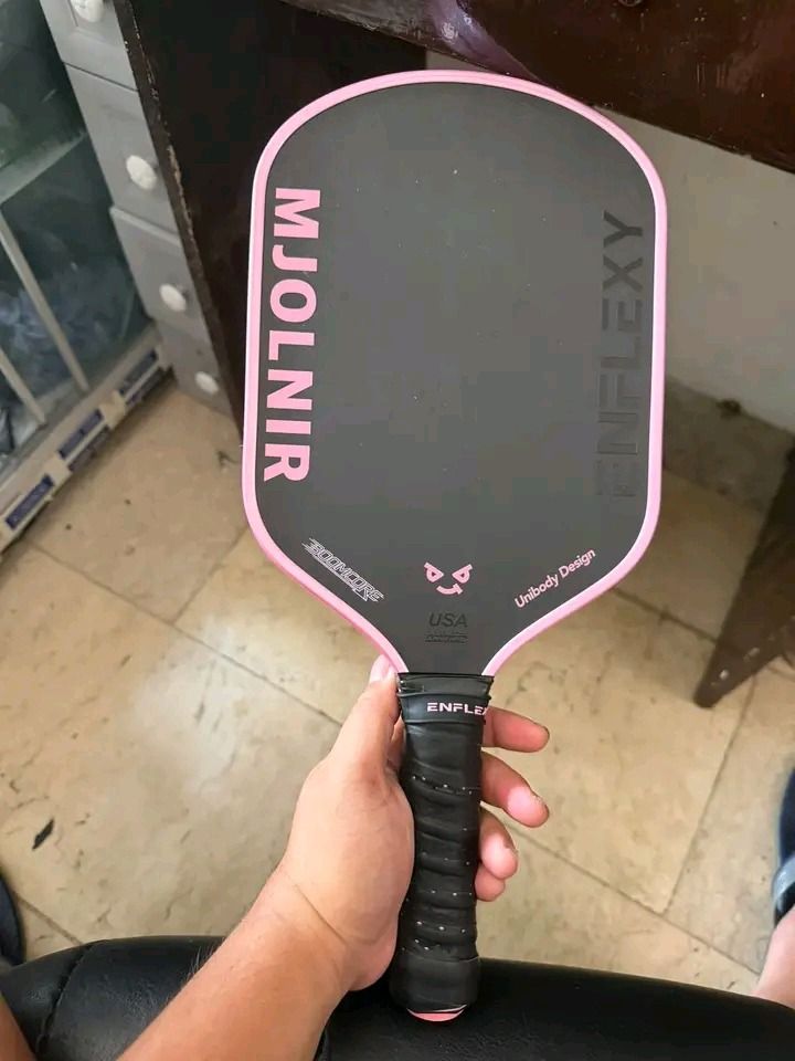 Enflexy Mjolnir 16mm Pickleball Paddle Pink (Category: Racket and Ball Sports) located in Atimonan. Submitted by brightriver_ee140a (Listing ID 1469097049, Image 1). Description: - Model: Enflexy Mjolnir Pickleball Paddle - Thickness: 16mm for enhanced stability and touch - Build: Durable unibody design with a striking black textured surface and pink trim - Grip: Standard wrapped black handle for comfortable play - Performance: Offers great contr