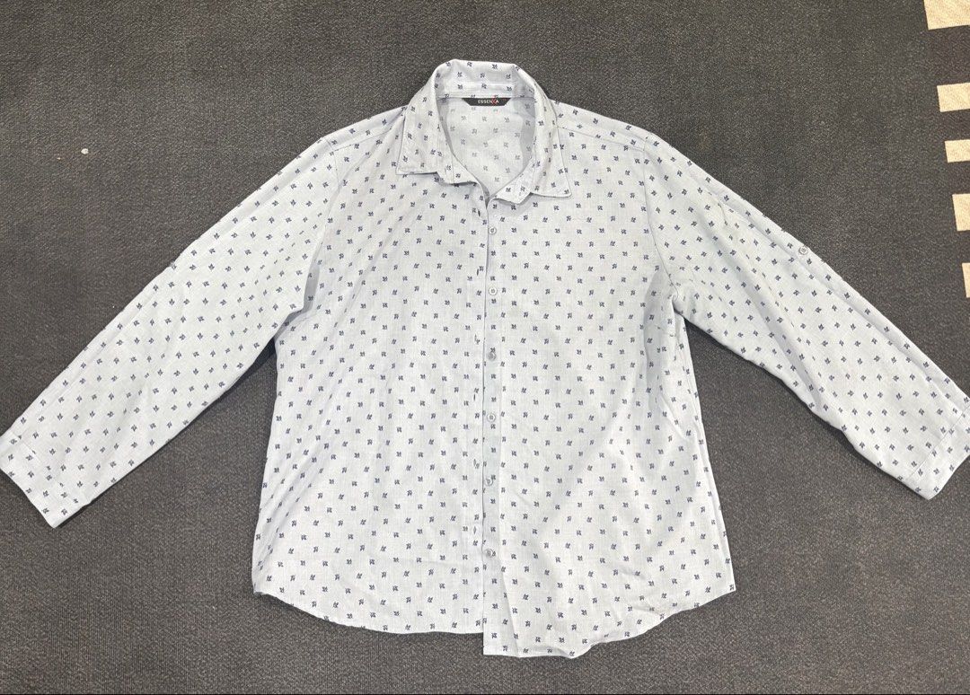 Essenxa A Light Blue Leaf Print Long Sleeve Shirt (Category: Longsleeves) located in Quezon City. Submitted by fast.closetfinds (Listing ID 1469013250, Image 1). Description: - Brand: Essenxa - Style: Long-sleeve button-down shirt with standard collar - Color/Pattern: Light blue with dark leaf pattern throughout - Details: Roll-up long sleeves with button tab detail - Size: XL - Material: Lightweight, comfortable fabric - Condition: Excellent, id
