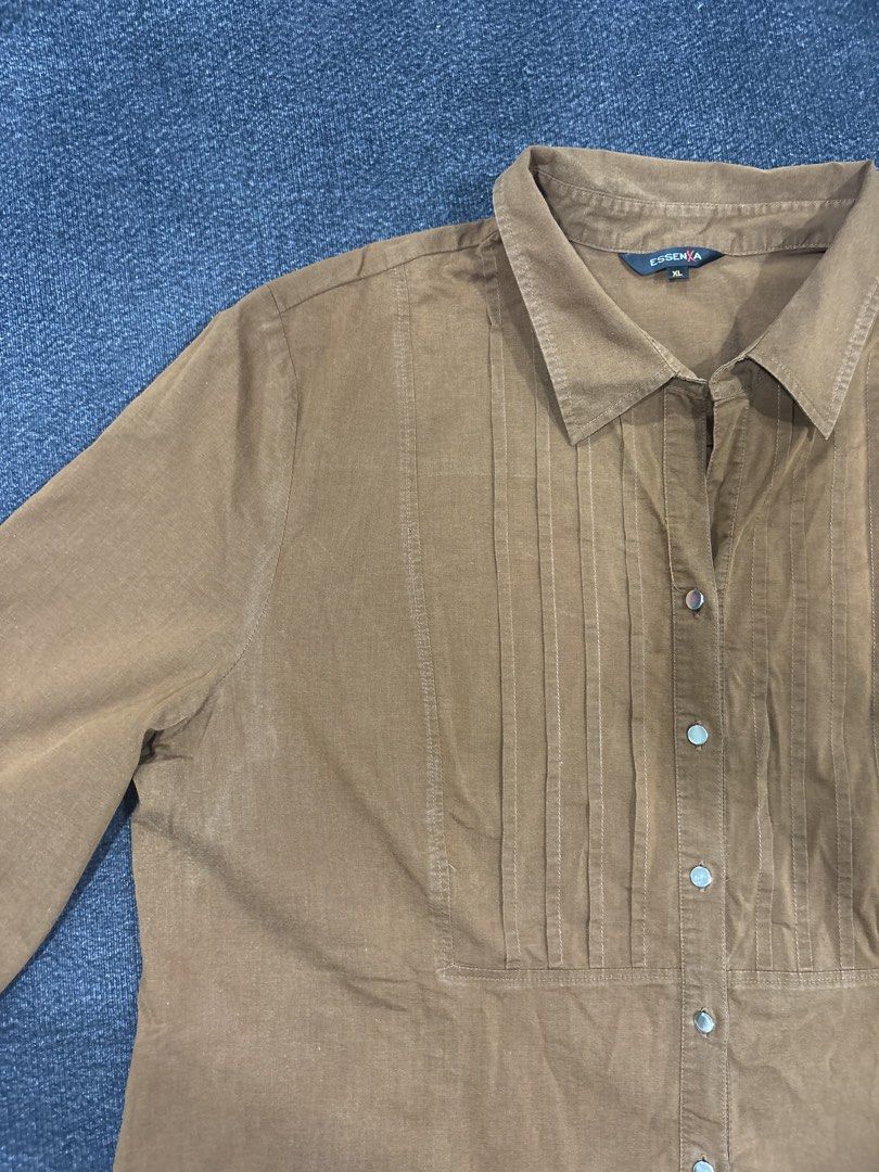 Essenxa Brown Long Sleeve Button Down Blouse Size XL (Category: Longsleeves) located in Quezon City. Submitted by fast.closetfinds (Listing ID 1469023755, Image 3). Description: - Brand: Essenxa - Size: XL - Color/Tone: Earthy brown - Style: Long sleeve button-down blouse with classic collar - Details: Elegant pleated front panel and button cuffs - Versatility: Perfect for both office work and casual outings - Condition: Good pre-owned condition,
