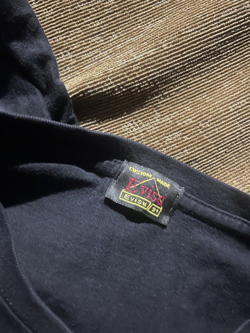 Evisu Black Graphic T-shirt (Category: Tshirts & Polo Shirts ) located in Kalibo. Submitted by mattpogi15 (Listing ID 1469028196, Image 3). Description: - Color: Black - Fit: Standard fit - Material: Comfortable cotton fabric - Design: White box logo on front chest - Back Detail: Large Japanese wave and koi fish graphic across shoulders - Details: Custom made neck tag inside - Style: Clean piece for streetwear fits.