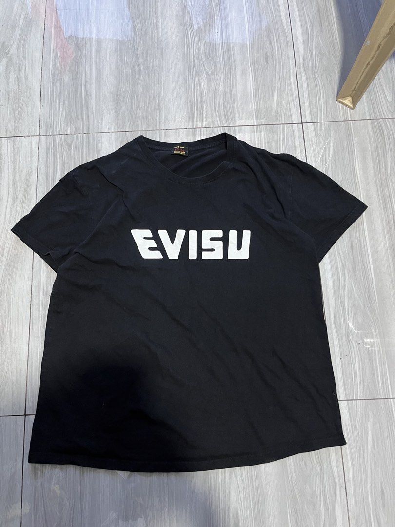 Evisu Black Graphic T-shirt (Category: Tshirts & Polo Shirts ) located in Kalibo. Submitted by mattpogi15 (Listing ID 1469028196, Image 1). Description: - Color: Black - Fit: Standard fit - Material: Comfortable cotton fabric - Design: White box logo on front chest - Back Detail: Large Japanese wave and koi fish graphic across shoulders - Details: Custom made neck tag inside - Style: Clean piece for streetwear fits.