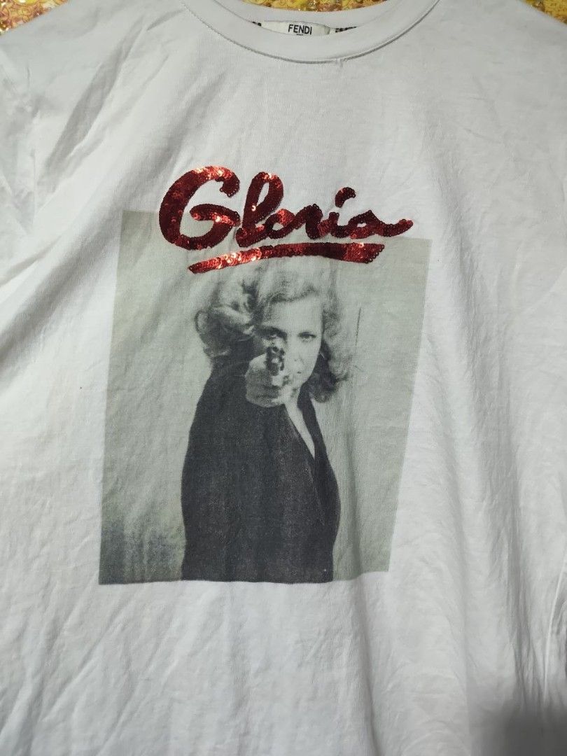 Fendi Gloria Lazer print (Category: Luxury Apparel) located in Paranaque City. Submitted by reymart_1 (Listing ID 1469111682, Image 3). Description: -This is a white Fendi Gloria Print T-Shirt featuring a black-and-white still graphic of Gena Rowlands from John Cassavetes's 1980 thriller Gloria, accented with red sequin embroidery spelling out "Gloria" across the top. -19x25 -like new condition -like new color rate -no flaws or stains -very good 