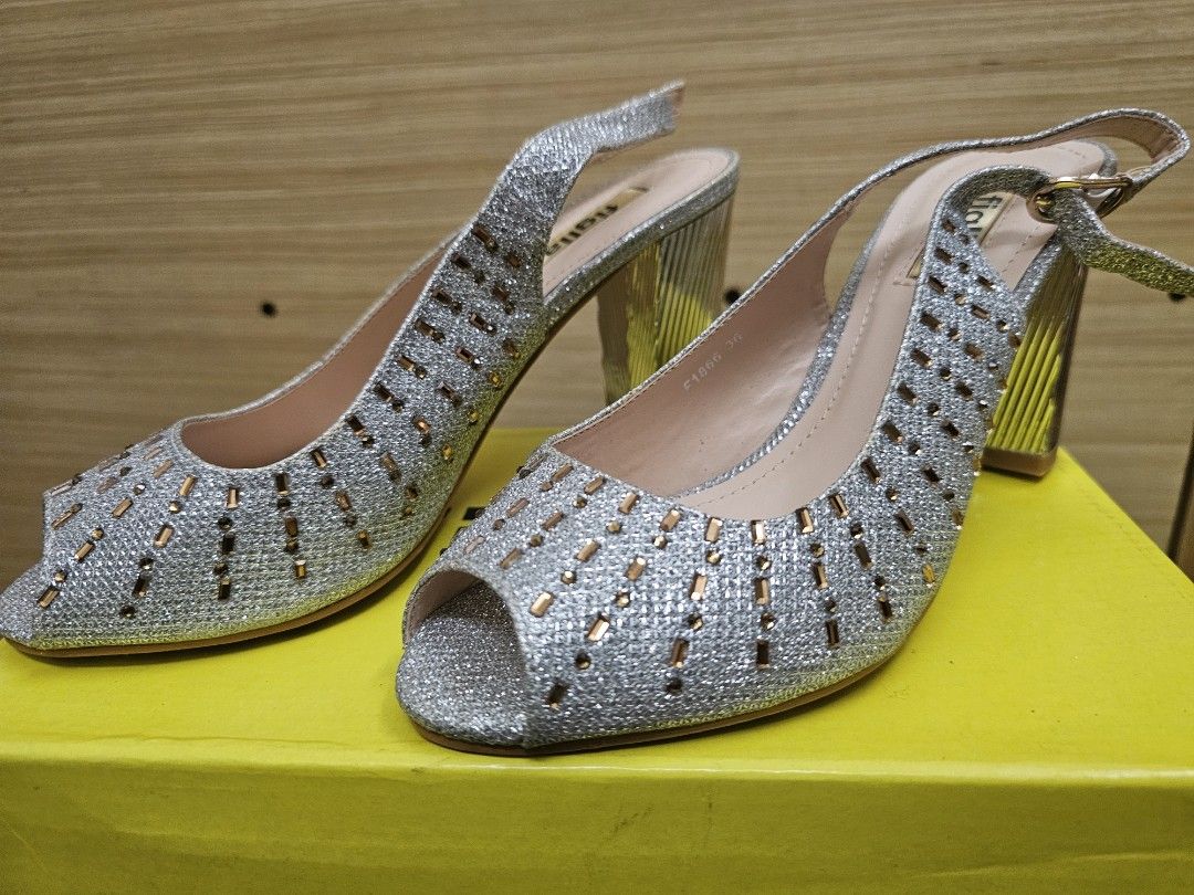 Figlia Silver Glitter Peep Toe Slingback Heels Size 36 (Category: Heels) located in Marikina City. Submitted by czarinahwithh (Listing ID 1469064255, Image 1). Description: - Brand: Figlia - Style: Glitter slingback heels with open toe - Color: Silver with chunky ribbed metallic heels - Details: Beautiful crystal and bead embellishments on the front, 3 inches heels - Fit: Size 36 (stamped inside) - Closure: Adjustable slingback strap with a gold 
