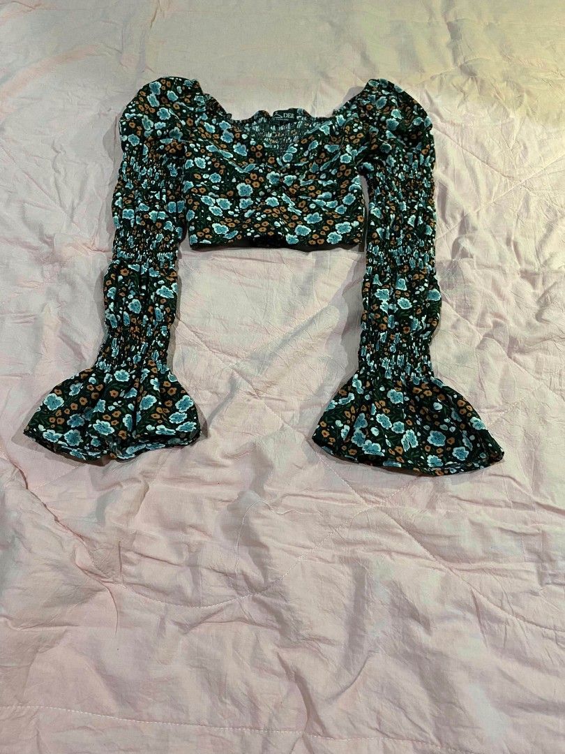 Floral long sleeve croptop (Category: Longsleeves) located in Santa Cruz. Submitted by gelpcz (Listing ID 1468950593, Image 2). Description: - Size: Small - Style: Floral long sleeve crop top with a trendy, cute vibe - Print: Dark background with all-over blue and orange flowers - Details: Smocked bodice and chic square neckline - Sleeves: Dramatic flared bell sleeves with smunching along the arms - Condition: Great addition to your wardrobe!.