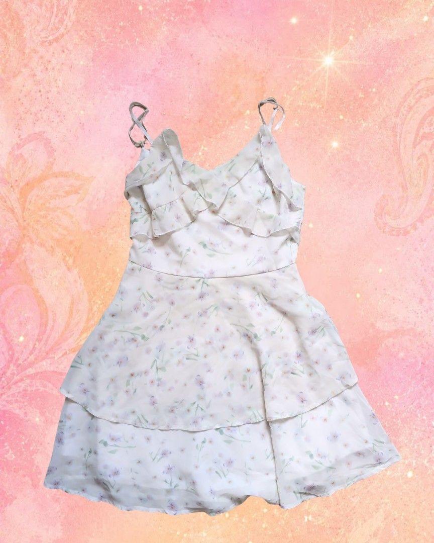 Floral Ruffle Strap Mini Dress (Category: Dresses) located in Antipolo. Submitted by mochisky (Listing ID 1468970955, Image 1). Description: - Style: Sleeveless mini dress with a tiered skirt - Print: White with all-over purple and blue floral design - Details: Thin adjustable straps and ruffled neckline trim - Fabric: Lightweight and comfortable for daily wear - Size: Small - Condition: Excellent / Ready to ship!.
