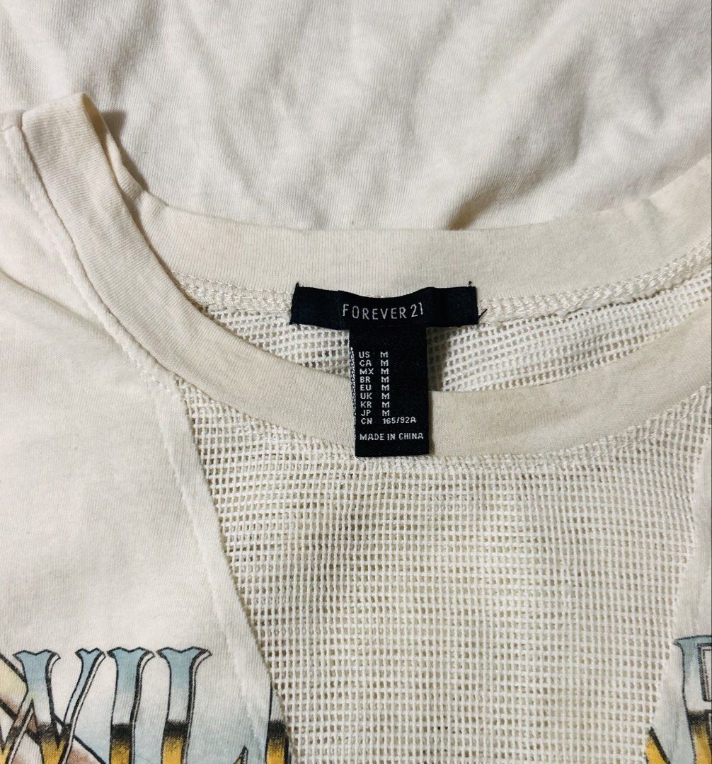 FOREVER 21 (Category: Sleeveless) located in Davao. Submitted by sart0ria85 (Listing ID 1468982111, Image 3). Description: A cream Wild Hearts Roam Free' eagle graphic print. Mesh V-insert panel at the neckline. 60%COTTON 40%POLYESTER MADE IN CHINA 🇨🇳 MEDIUM. Size 6 EXCELLENT CONDITION (94/100).