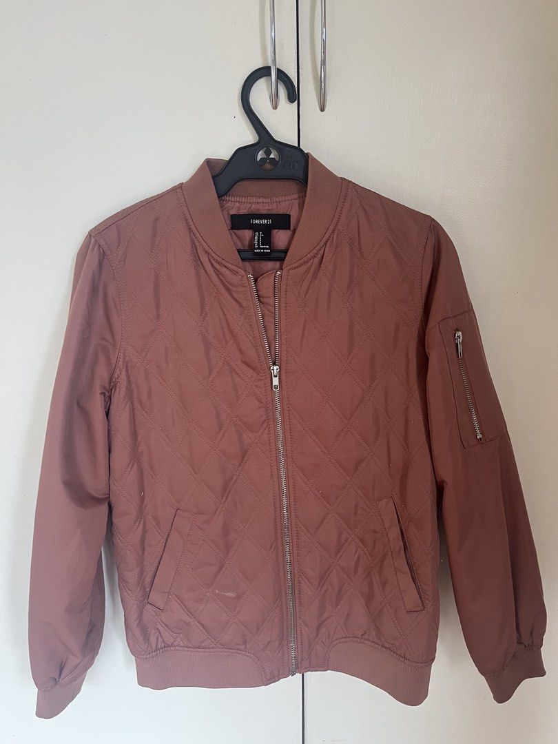 Forever 21 Bomber Jacket Mauve Pink (Category: Coats, Jackets and Outerwear) located in Baguio. Submitted by silvercat.0f61c5 (Listing ID 1468960371, Image 1). Description: - Brand/Model: Forever 21 Quilted Bomber Jacket - Color: Dusty Mauve Pink - Size: Small (S) - Design: Diamond quilted front panels with solid sleeves and back - Details: Full front zipper, ribbed collar, cuffs, and hem - Pockets: Two front welt pockets plus a zippered utility 