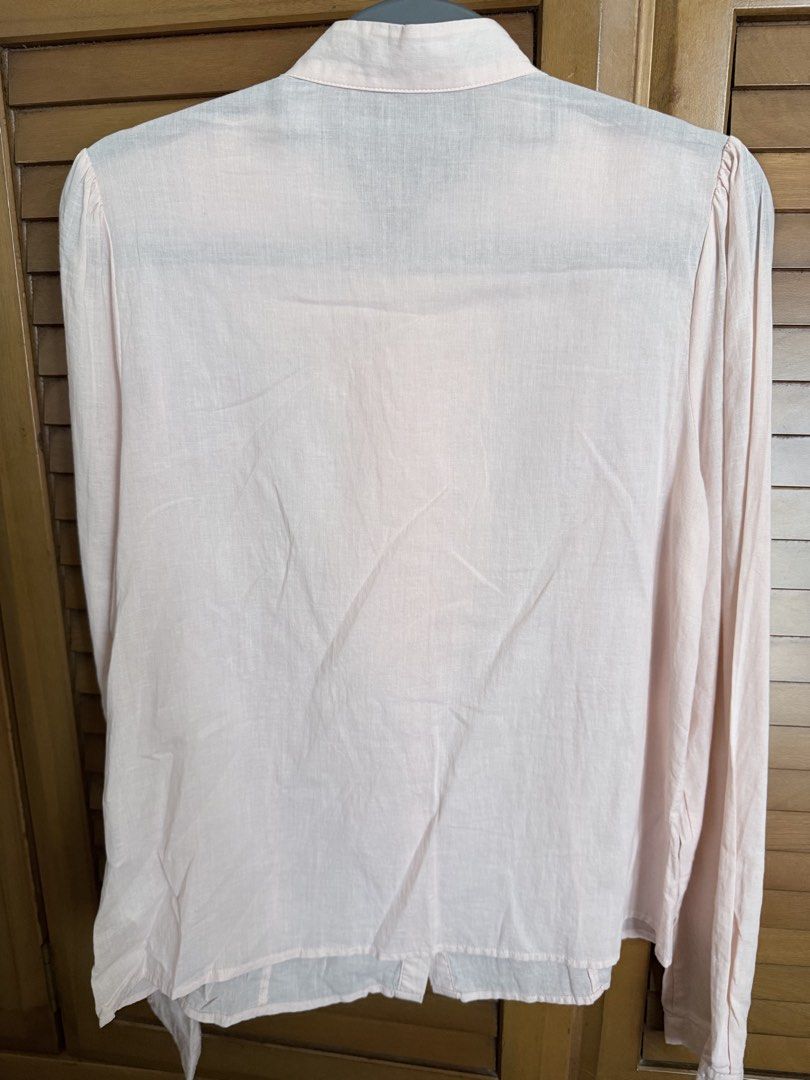 Forever 21 Light Pink Ruffled Long Sleeve Blouse (Category: Longsleeves) located in Paranaque City. Submitted by roanclauds (Listing ID 1468957023, Image 2). Description: - Brand: Forever 21 - Color: Pale pink with tonal buttons - Material: Soft, comfortable fabric - Design: Long sleeves, layered front ruffles, stand-up collar, and shoulder gathers on the back - Fit: Standard fit - Condition/Occasion: Great for work or casual outings.