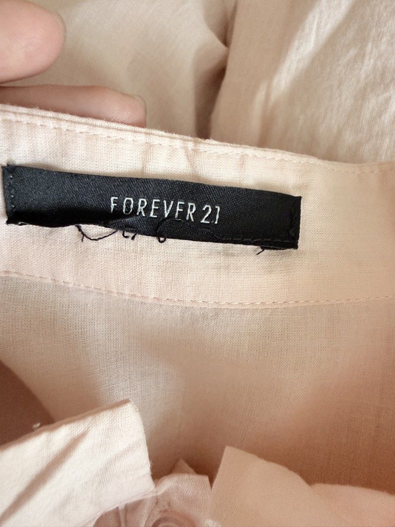 Forever 21 Light Pink Ruffled Long Sleeve Blouse (Category: Longsleeves) located in Paranaque City. Submitted by roanclauds (Listing ID 1468957023, Image 3). Description: - Brand: Forever 21 - Color: Pale pink with tonal buttons - Material: Soft, comfortable fabric - Design: Long sleeves, layered front ruffles, stand-up collar, and shoulder gathers on the back - Fit: Standard fit - Condition/Occasion: Great for work or casual outings.