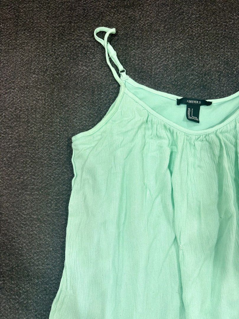 Forever 21 Mint Green Cami Top Size S (Category: Sleeveless) located in Quezon City. Submitted by fast.closetfinds (Listing ID 1469021535, Image 1). Description: - Brand: Forever 21 - Size: S - Color: Mint Green - Details: Adjustable spaghetti straps, cute crochet lace trim on the bottom hem - Fabric: Lightweight and textured, perfect for hot weather - Condition: Good, with a small snag near the front middle section (priced accordingly).