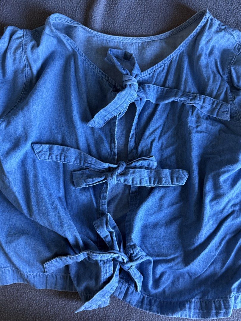 Forme Denim Blue Tie-Back Top Size L (Category: Blouses) located in Pasig City. Submitted by laagn.ph (Listing ID 1469088781, Image 3). Description: - Brand: Forme - Color: Denim Blue - Size: M - Design: Tie-back with multiple bow closures and trendy ruffled bell sleeves - Material: Lightweight chambray, perfect for casual days - Condition: Pre-loved (check label tag for sizing details).