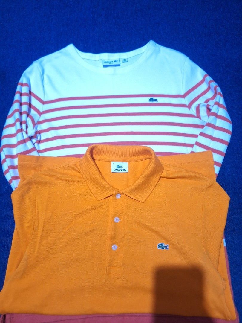 Forsale. Aspack same size medium very good condi (Category: Tshirts & Polo Shirts ) located in Manila. Submitted by adolphreyes645 (Listing ID 1468962579, Image 2). Description: - Bundle includes 2 classic Lacoste tops - Item 1: Bright orange polo shirt with buttons and iconic crocodile logo - Item 2: White long sleeve shirt with red horizontal stripes and small chest logo patch - Timeless casual wear style - Great value bundle, message to order!